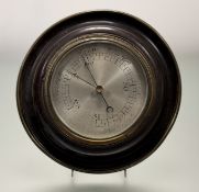 A 1920s mahogany framed circualr aneroid wall barometer with silvered dial and brass-mounted frame -