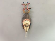 An African Tribal carved wooden mask with polychrome intricately carved top with wall hanging string
