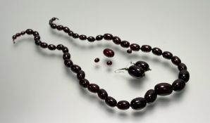 A vintage strand of graduated dark treacle amber beads on knotted strand missing fastening: l. x