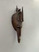 A Marka Mali tribal carved wooden mask, decorated with an elongated triangular face and slit eyes,