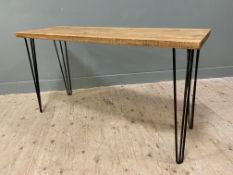 An oak plank top table, from the collection of Glenmorangie, plank top raised on black metal