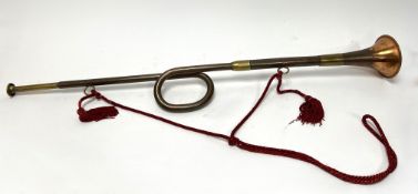 A copper and brass hunting horn with twisted neck and red rope sash (l. 80cm)