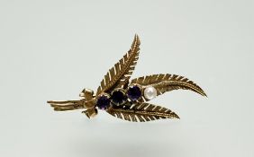 A 9ct gold fern brooch set three amethysts and seed pearl: h. x 5cm 3.96g