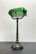 An early 20thc brass and green glass bankers table lamp with adjustable shade, raised on a