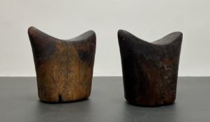A pair of African Tribal hardwood headrests of tapering form with oval bases and shaped tops (h.