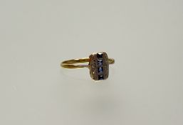 A 1920s yellow and white metal ring set four cushion cut sapphires bordered by four diamond