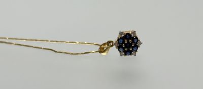 A Thai 18ct gold pendant set seven round cut sapphires approxiamtely 0.9ct and six diamond points on