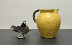 A terracotta pitcher with hand painted floral design on a yellow glazed ground and green handle (