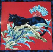 A Revillon Paris, on red ground a Panther amongest ferns, silk scarf, mounted in a glazed frame. (