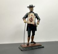 A vintage J.V.E Dutch cast metal peddler clock in the form of a clock seller with key and