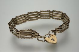 A 9ct gold gate link style bracelet with heart shapped padlock and safety chain: d. x 8cm 8.72g