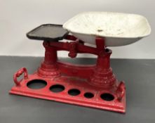 A set of vintage cast iron kitchen scales painted red, with large weighing bowl and pierced area