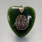 An Edwardian spinnich green jade heart shaped pendant mounted with loop to top and yellow metal