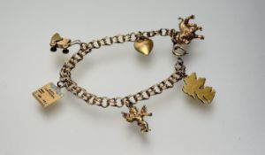 A 14K gold double ring chain bracelet with ring fastening set six charms to include a yellow metal