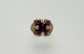 A 9ct gold cocktail ring set oval garnet to centre approximately 1ct flanked by four sets of three