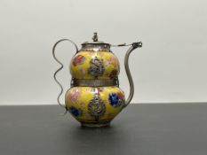 A Chinese Tibetan porcelain teapot with white metal accents, blue and red chrysanthemums on a yellow