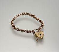 A 9ct solid rose gold kerb link chain bracelet with 9ct yellow gold engraved heart shaped lock: d. x