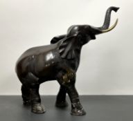 A large Japanese-style bronze elephant with raised trunk and brass tusks (a/f to one tusk) (h. 50cm)