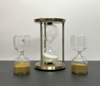 A pair of handblown octagonol clear glass hourglass timer with gilt micro beads (h. 16cm),