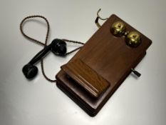 A teak cased wall-mounted telephone with winding handle and Bakelite handset by TEL Beeston