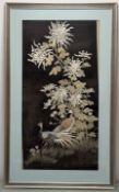 A Chinese silk thread framed work, depiting two cranes by a blossoming white plant, one black