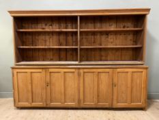 An early 20th-century pine country house kitchen dresser, moulded cornice above four shelves to top,