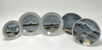 A collection of Highland Stoneware plates comprising a pair with cenral panels decorated with hill