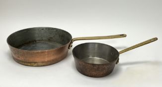 A large copper saucepan with long brass handle (d. 31cm), together with a smaller example (d. 20.