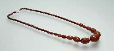 A vintage dark butter scotch graduated amber bead necklace with ring fastening: largest bead l. x
