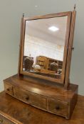 A 1930's mahogany swing mirror, rectangular plate raised on fluted square supports with urn