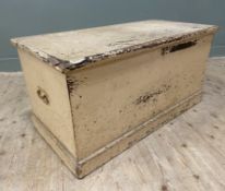 An early 20th-century pine blanket box, with distressed pink finish lifting to reveal storage to