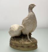 An early 20thc Royal Dux porcelain group of modelled as two grouse, raised on naturalistic oval base