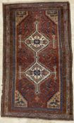 An antique hand-knotted tribal rug, possibly Qashqai, central panel with twin diamond-shaped