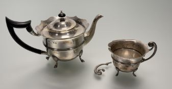 An Edwardian Birmingham silver two-piece tea set comprising a tea pot with ebonised handle and