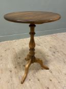 A modern elm tripod table, by Ercol, circular top raised on baluster support with tripod base: H.