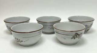 A collection of five Highland Stoneware bowls, each decorated with floral motifs (h. 10.5cm x d.