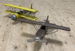 Two contemporary model hanging aeroplanes, one wooden and one metal, suspended from chains: Wingspan