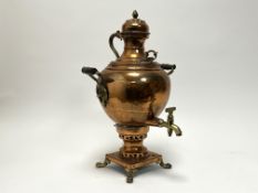A 19thC hammered copper Samovar with brass twin handles, a brass finial to top, and raised on four
