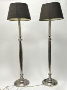 A pair of nickel table lamps in the form of candlesticks, raised on circular bases with brown