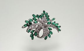 An 18ct white gold brooch pendant set brilliant cut diamond scroll and oval facet cut emeralds: l. x