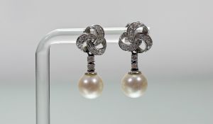 A pair of 18ct white gold cultured pearl drop earrings with scrolling diamond millegrain set