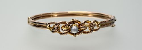 An Edwardian 15ct gold bangle with graduated ropetwist centre set with a single pearl with clip