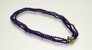 A graduated triple strand amethyst bead necklace mounted on 9ct gold clasp fastening with a