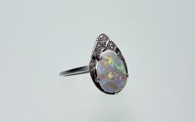 A 1920s white metal ring set pear-shaped fire opal mounted in five claw setting and eight