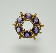 An Edwardian 15ct gold brooch set six round facet cut amethysts approximately 1ct each interspaced