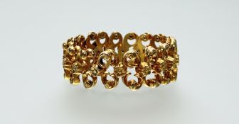 An 18ct gold expanding bracelet, of fancy links modelled as flowerheads and scrolls, stamped 