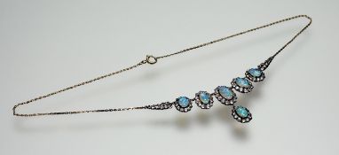 A 9ct gold collet drop necklace set six graduated oval fire opals within a surround of faceted round