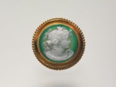 An Etruscan Revival green and white intaglio circular brooch depicting a garlanded Classical