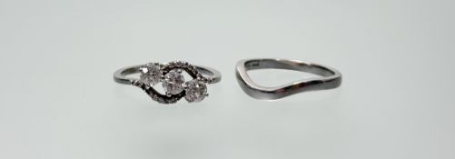 A three-stone diamond crossover ring, the uniform old mine-cut stones claw set between shoulders