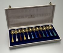 A cased set of twelve Norwegian silver-gilt and enamel coffee spoons, David Andersen, the handles in